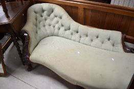 A Victorian mahogany framed chaise longue, having a shaped and deep buttoned back with foliate