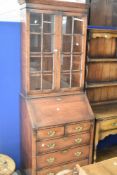 A good quality oak reproduction bureau bookcase having glazed upper section , drop flap with