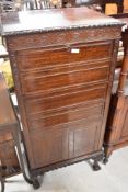 An early 20th Century mahogany music cabinet having four drop front drawers, and lower cupboard