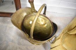 A traditional brass warming pan and coal helmet