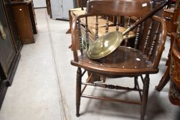 A late 19th or early 20th Century spindle back captains chair and a traditional bed warming pan