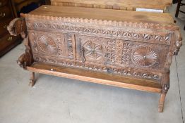 A traditional Indian Dowry chest having extensive carving with two thirds sliding door front,
