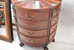 A modern hardwood demi lune multi drawer chest having sun burst veneer pattern to top, dimensions