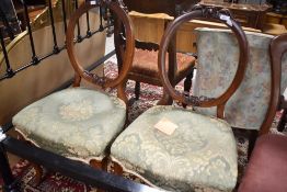 A pair of Victorian mahogany balloon back salon chairs having overstuffed seats and shaped legs