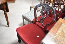 A set of four Victorian mahogany balloon back dining chairs having red velvet upholstered seats,