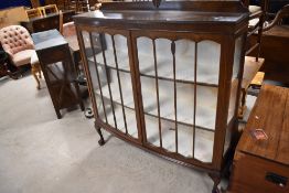 An early 20th Century oak china cabinet having ledge back and ball and claw feet, width approx.