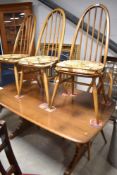 A mid stain Ercol refectory style dining table and set of six similar hoop and stick back chairs