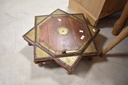 A traditional Indian hardwood and brass bajot table of star form, width approx. 61cm, height 12cm