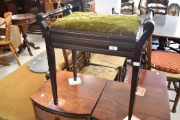 An Edwardian stained mahogany piano stool, with hinged and padded box seat between turned handles,