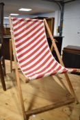 A vintage wooden frame deckchair with candy stripe seat