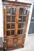 A nice quality reproduction oak bookcase with panelled cupboard under, probably Titchmarsh and