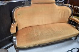 A Victorian inlaid mahogany two piece suite, comprising settee and armchair with carved and inlaid