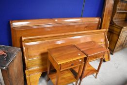 A modern hardwood 6 foot sleigh bed and two similar beside tables