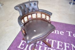 A reproduction brown leather swivel office chair, captains style