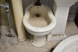 A late 19th/early 20th century white glazed porcelain bidet, of typical design