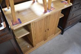 A modern oak side cabinet having central cupboard flanked , dimensions approx. W91 H73 D45cm