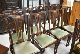 A set of eight Edwardian mahogany dining chairs having inlaid decoration, feathered slat backs and