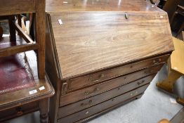 A Georgian mahogany bureau having fitted interior beneath fall flap , over four long drawers and