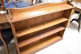 An early 20th Century golden oak low bookshelf in the Arts & Crafts style, of shallow proportions,