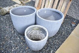 Three composite garden planters of barrel form (two plus 1)