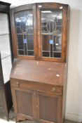 An early 20th Century oak bureau bookcase, one piece construction, having upper lead glazed