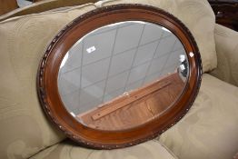 An early to mid 20th Century mahogany oval wall mirror, approx. 63 x 88cm