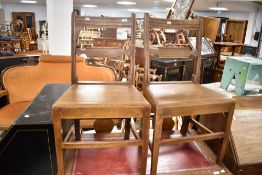 A pair of Georgian oak farmhouse style chairs having solid seats and shaped rail back, seat width