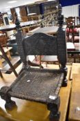An Antique Low/Pidha chair, probably from the Indian subcontinent region, having carved back and