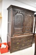 A period oak linen cupboard, having typical extensive carved decoration plus mythical creatures,