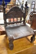 An Antique Low/Pidha chair, probably from the Indian subcontinent region, having carved mythological