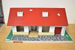 A mid-20th century dolls house in the form of a bungalow, possibly by Tri-ang. The model is of