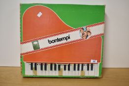 A vintage toy tabletop piano manufactured by Bontempi, presented in its original illustrated