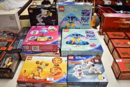An assortment of factory-sealed LEGO construction sets and boxed die-cast vehicle models. The