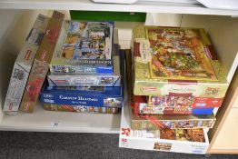 A collection of nine boxed jigsaw puzzles featuring various traditional and festive subjects. The