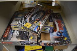 A collection of various boxed toys and model sets. The group includes two large slot car racing