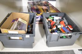 A mixed collection comprising two grey plastic storage crates filled with various toy vehicles and a