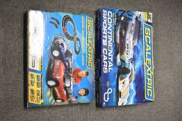 A pair of boxed Scalextric 1:32 scale electric slot car racing sets. The first set is titled