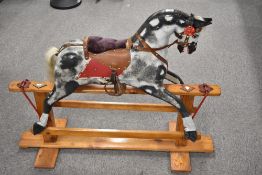 This safety glider rocking horse is manufactured by F.H. Ayres Ltd of London. The carved wooden body