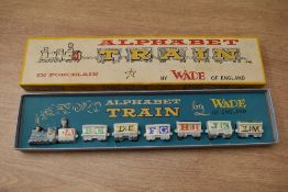 A Wade English porcelain alphabet train, consisting of engine and six carriages, in original box.