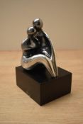 A contemporary Devora Jaron white metal figure group, modelled as a couple embracing, marked D.Jaron