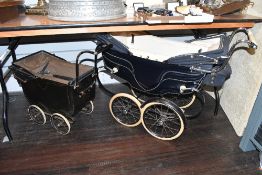 A mid 20th-century Silver Cross twin dolls pram, featuring two hoods in the navy and cream