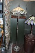 A tall contemporary Tiffany-style standard lamp, featuring an ornate finial, an Art Noveau-style