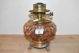 A Victorian Arts and Crafts brass and copper oil lamp, having a heavily hammered body of