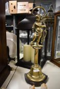 A tall Victorian brass and cast iron door porter, featuring a cherub figure raised upon a