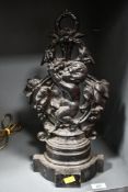 A Victorian cast iron door porter, featuring a winged cherub eating grapes against a foliate