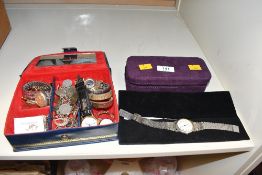 A blue jewellery box containing an assortment of costume jewellery including wristwatches, a