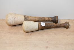 Two late 19th-century stoneware apothecary pestles, having turned wooden handles, of graduated