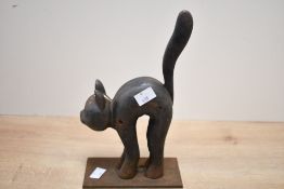 A late 20th-century Past Times cast iron black cat doorstop, featuring a stylised cat with a high