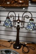 A contemporary Tiffany-style table lamp, featuring two floral shades upon a spiralled Art Nouveau-