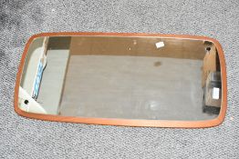 A 20th-century Danish-style teak wood framed wall mirror, of rectangular form with rounded asymmetr